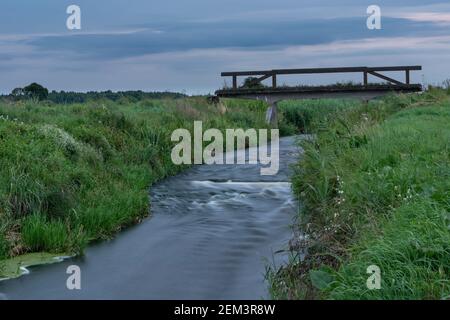 The old bridge over the Uherka river and the evening sky, Czulczyce, Poland Stock Photo