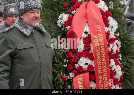 Moscow, Russia. 23rd Feb, 2021. A man stands next to a wreath from communists on the square in front of the tomb of the Unknown Soldier under the Kremlin wall. The Communist Party of the Russian Federation on Tuesday gathered activists of the Left Front, the Lenin Komsomol, the movement For New Socialism, the women's union “Hope of Russia” and other related organizations to lay flowers at the Tomb of the Unknown Soldier in the center of Moscow. Credit: SOPA Images Limited/Alamy Live News Stock Photo