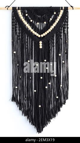 Hand woven black macrame with white beads hanging on wall