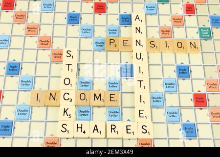 Stock shares and annuities, phrase on a scrabble board with stocks shares annuities in white for emphasis Stock Photo