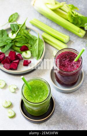 Vegan diet and nutrition, healthy detox, vegetarian concepts drinks. Beet smoothie and Green smoothie celery and spinach on a gray stone countertop. Stock Photo