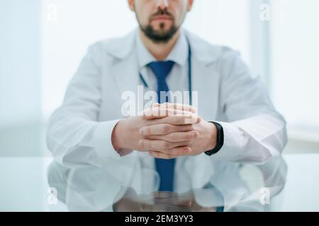 thoughtful doctor with a stethoscope sitting at his desk. Stock Photo