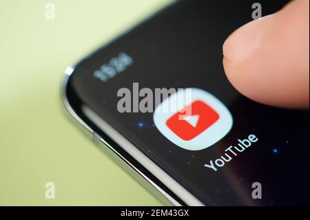 New york, USA - February 24, 2021: Youtube app on smartphone screen touch with finger macro close up view Stock Photo