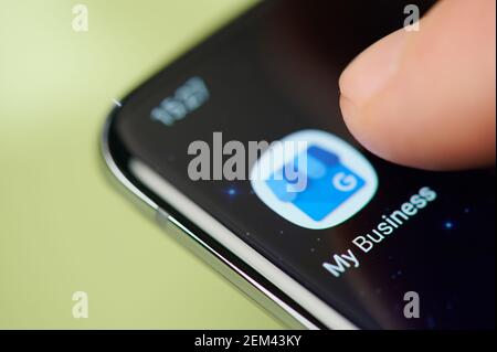 New york, USA - February 24, 2021: Google my business app on smartphone screen touch with finger macro close up view Stock Photo