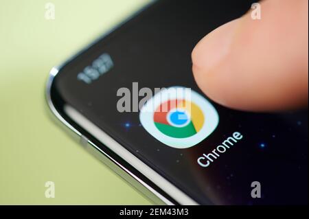 New york, USA - February 24, 2021: Chrome app on smartphone screen touch with finger macro close up view Stock Photo