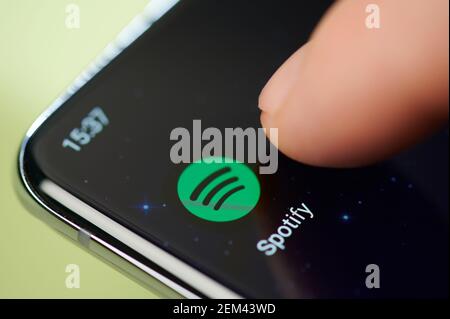 New york, USA - February 24, 2021: Spotify app on smartphone screen touch with finger macro close up view Stock Photo