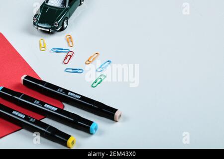 Colorful pencils, clips, red paper and toy car on white background Stock Photo