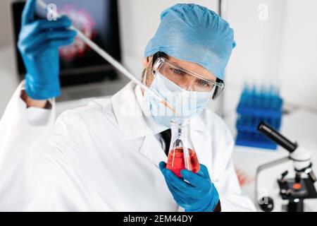 close up. the scientist carefully looking at the test tube . Stock Photo