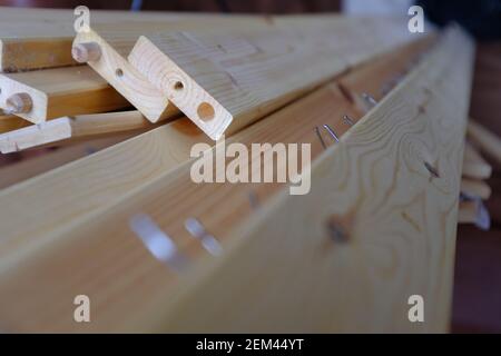 Wooden planks left over from an old bed frame. The images focus is on the dowel joint at the end of the material. Stock Photo
