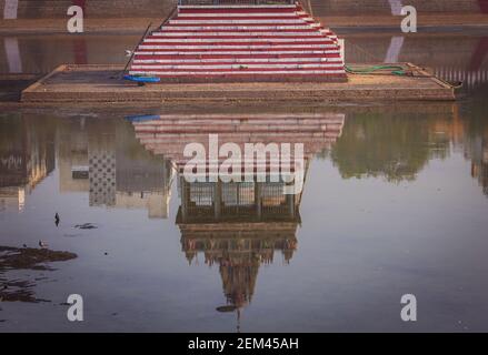 Reflection of the temple tower in the temple tank which stores water Stock Photo