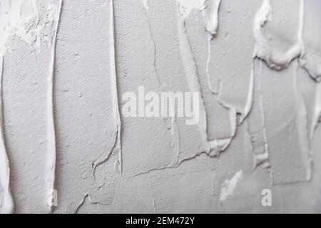Fresh wet plaster on walls before leveling, gray texture for apartment renovation. Stock Photo