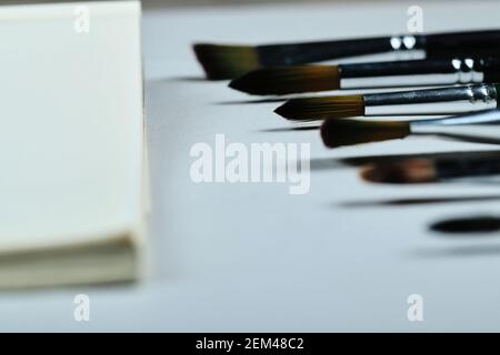 Paintbrushes and empty notebook on white background Stock Photo