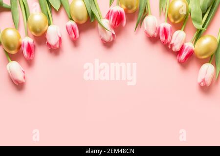Easter greeting card with tulips, golden eggs on pink background with copy space. Stock Photo