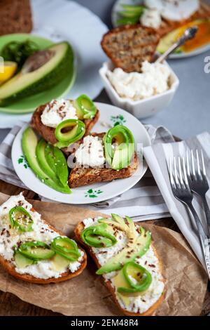 Sandwiches with soft cheese, avocado and cucumber. Breakfast is on the table. Healthy food. Toast and spread on it. Avocado sandwich stilllife. Health Stock Photo