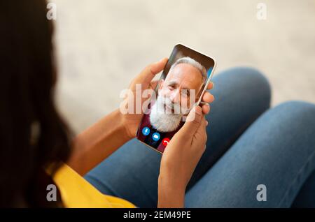 Woman making video call with old man using smartphone Stock Photo