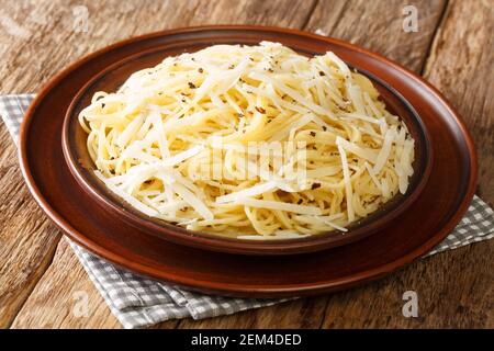 Cacio e Pepe is a Roman pasta dish that translates to cheese and pepper closeup in the plate on the table. Horizontal Stock Photo