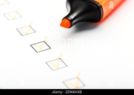 Orange marker with markers on the checklist sheet. Checklist completed task concept. Stock Photo