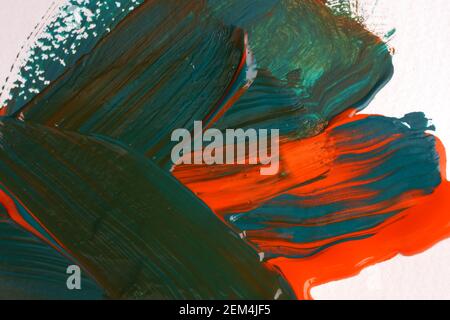 Orange and green brush strokes applied by paint brush to the paper, close-up Stock Photo