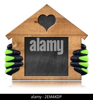 Gloved hands showing a small wooden house with a blank blackboard inside in the shape of a rectangle and heart. Isolated on white with copy space. Stock Photo