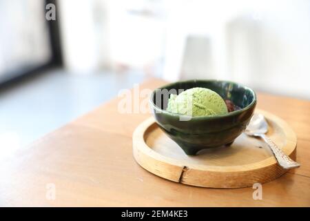 Japanese green tea ice cream with red bean topping on wooden table in coffee shop Stock Photo