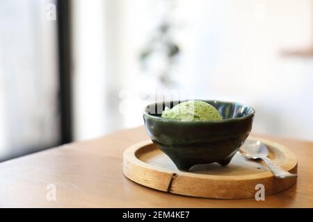 Japanese green tea ice cream with red bean topping on wooden table in coffee shop Stock Photo