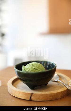 Japanese green tea ice cream with red bean topping on wooden table in coffee shop Stock Photo