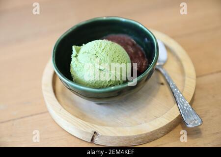 Japanese green tea ice cream with red bean topping on wooden table in coffee shop Stock Photo