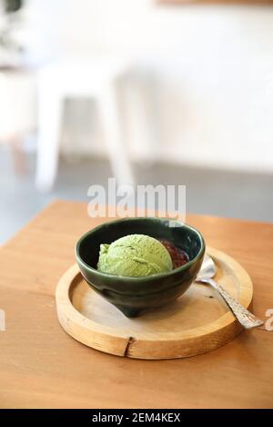 Japanese green tea ice cream with red bean topping on wooden table in coffee shop Stock Photo