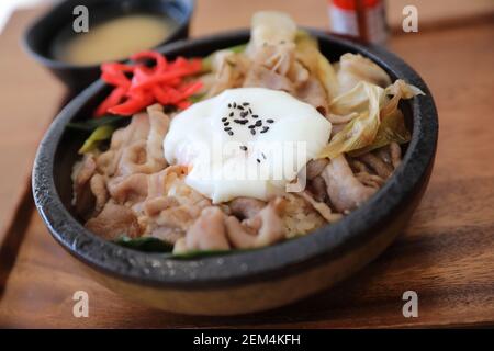 Japanese food Gyudon Japanese beef on rice bowl topped with egg on wooden table Stock Photo