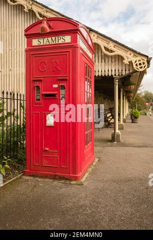 An unusual combination of a postage stamp vending machine, mail box and public telephone kiosk at a heritage railway station in Somerset UK