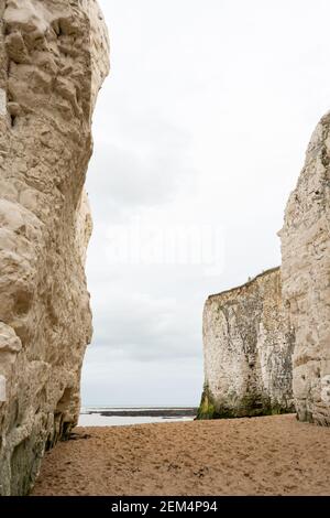 Portrait photograph of sandy beach in between chalk cliffs at botany bay, broadstairs kent, England on cloudy day with space for copy Stock Photo