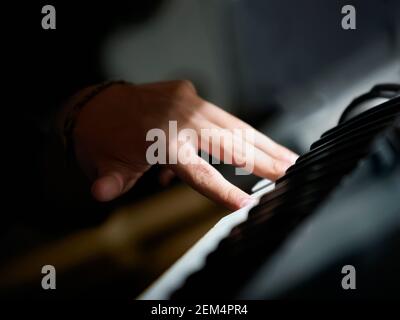 Close-up of a person's hand playing an electric piano Stock Photo