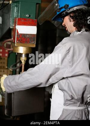 Side profile of a manual worker working on a spot welding machine Stock Photo