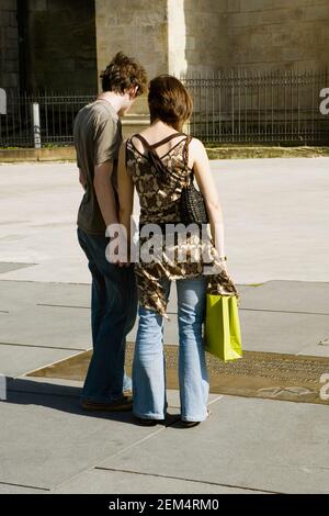 Rear view of a young couple standing and holding hands Stock Photo