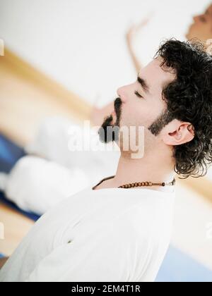 Side profile of a mid adult man meditating Stock Photo