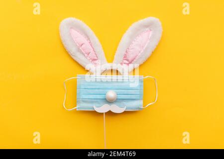 Coronavirus Easter bunny face made from rabbit ears and a protective face mask Stock Photo