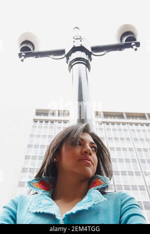 Low angle view of a young woman with a lamppost Stock Photo