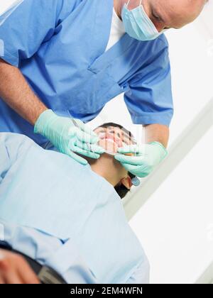Low angle view of a young man getting his teeth examined by a dentist Stock Photo
