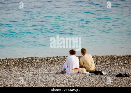 Rear view of a young couple relaxing on the beach Stock Photo
