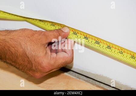 Close-up of a man's hand measuring with a tape measure Stock Photo