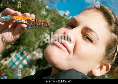 Portrait of a young woman holding a bar of chocolate Stock Photo