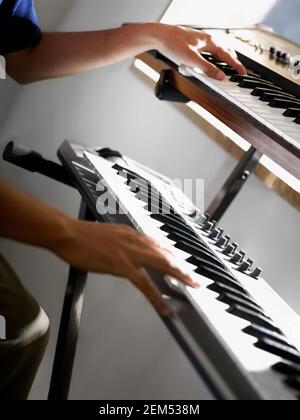 Close-up of a person's hands playing two electric pianos Stock Photo