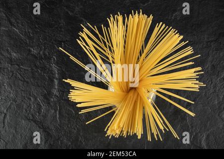 Raw dry spaghetti in a glass jar on a black background Stock Photo