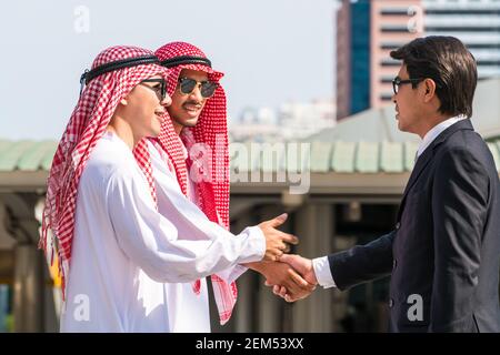 Arabic, Asian businessmen discussion in business meeting. Modern city background. International business and overseas Arab business cooperation. Stock Photo