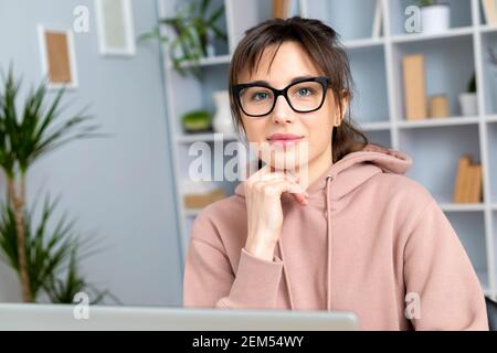 Portrait of a young woman with glasses sitting in the office. Stock Photo