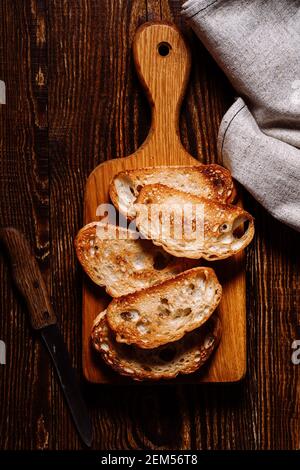 Toasted bread on rustic wooden table, top view Stock Photo