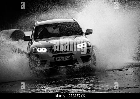 Riga, Latvia 10 february 2021 - bmw rides on water, spray from the car. Front view. Stock Photo