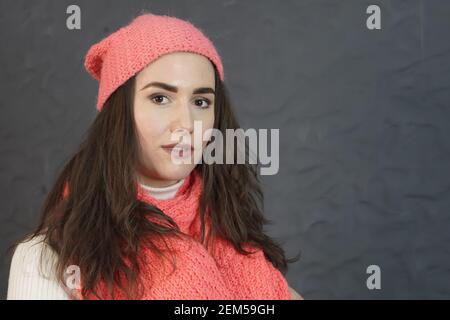 Portrait of a girl, natural look, with long hair in a pink knitted hat Stock Photo