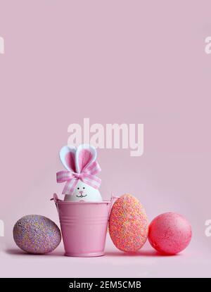 Easter holiday concept with cute handmade eggs, bucket and bunny ears. Easter holiday decoration. Stock Photo