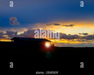 Setting sun shining through the Bude Cricket club clubhouse, Cornwall, UK Stock Photo